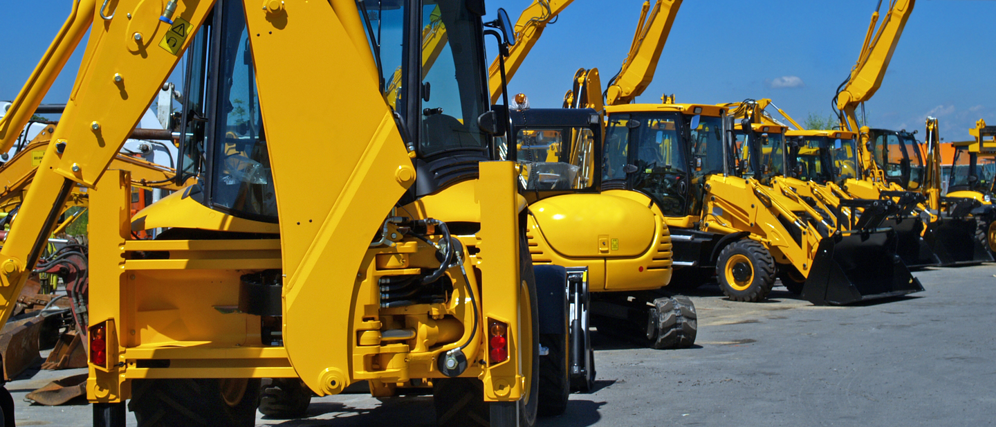 Row of large construction equipment vehicles.