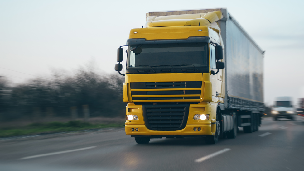 Truck carrying cargo driving on highway.