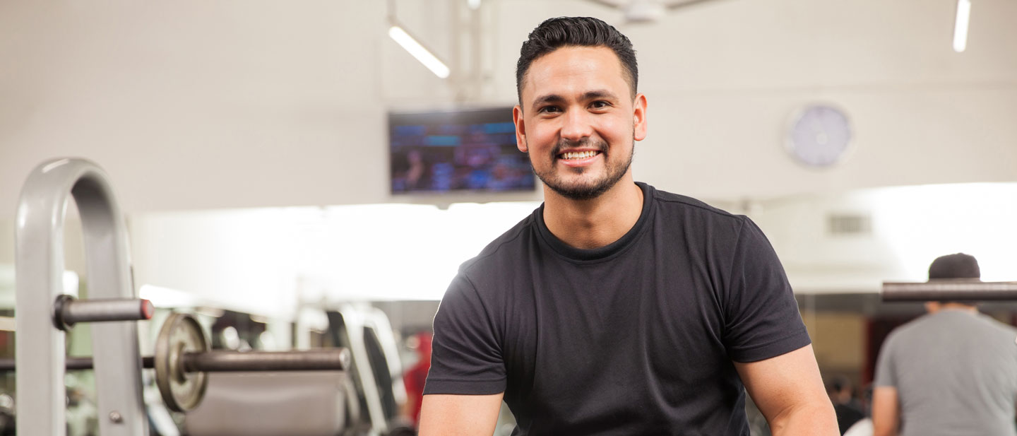 Young male sitting on a bench at the gym.