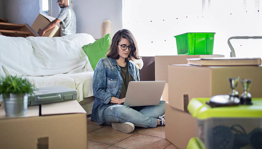 Young renter sitting on floor of apartment.